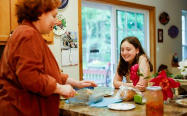 Woman preparing food with a girl watching